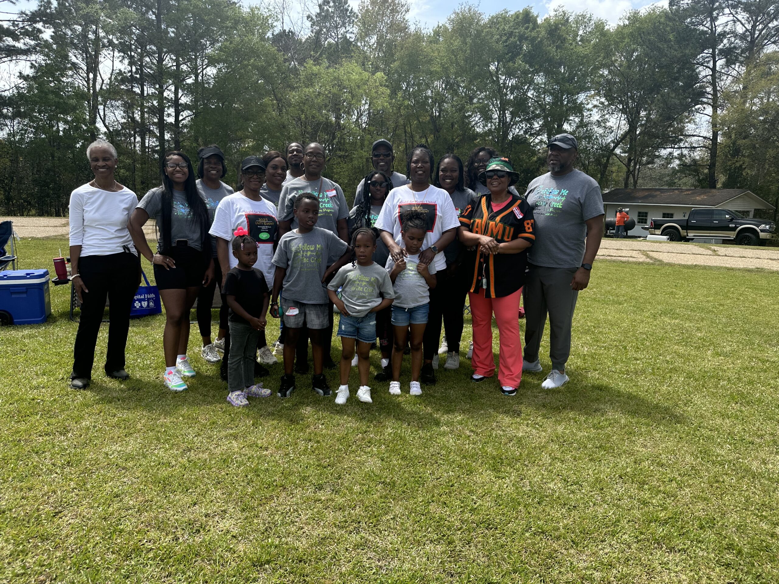 multi-generation group standing on a green field