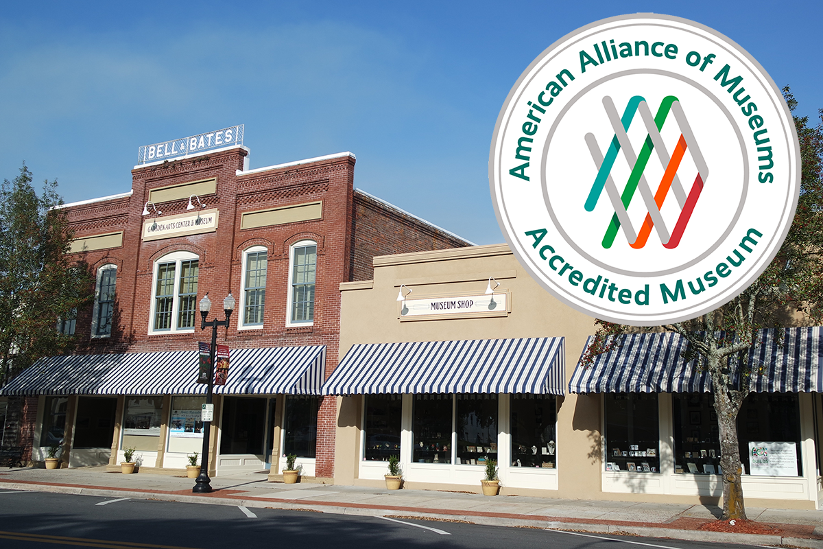 Exterior street view of the historic Gadsden Arts Center & Museum in Quincy featuring brick architecture, striped awnings, and an inset seal showing American Alliance of Museums accreditation.