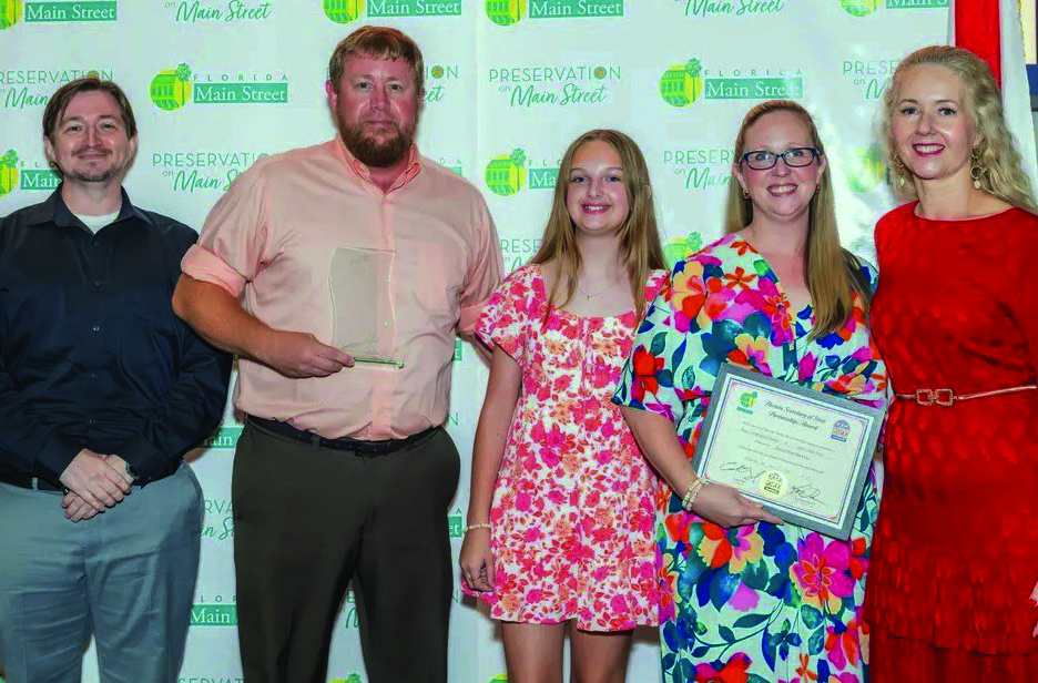 Group photo at the Florida Main Street conference showing Josh Kever, Roger and Bridgette Rankin, their daughter Lilly, and Melissa Wylie holding an award certificate.